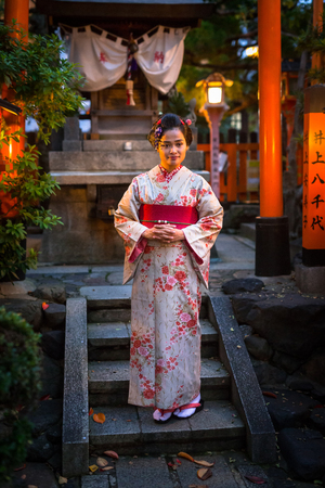 KYOTO, JAPAN - NOVEMBER 10, 2016: Young woman wearing traditional japanese kimono walk on the street of Gion, Kyoto old town, Japan. Kimono is a Japanese traditional garment.のeditorial素材