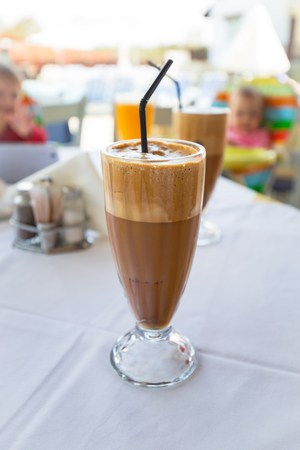 Glass of freppe - greek cold iced coffee on tableの写真素材