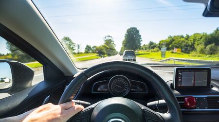 Steering wheel of a car at driveの写真素材