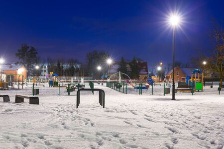 Snowy winter at the playground at dusk, Polandの写真素材