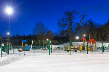 Snowy winter at the playground at dusk, Polandの写真素材
