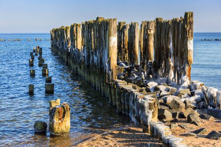 Frozen wooden breakwaters line at Baltic Sea, Babie Doly, Polandの写真素材