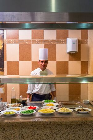 HURGHADA, EGYPT - APR 15, 2013: Cook serving breakfast at Three Corners Sunny Beach hotel in Hurghada. Three Corners is Belgian company with 11 hotels at Red Sea in Egypt and one in Budapest, Hungary.のeditorial素材