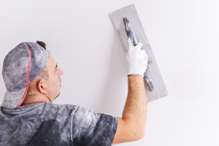 Plasterer applying gypsum plaster on the wall. House renovation concept.の写真素材