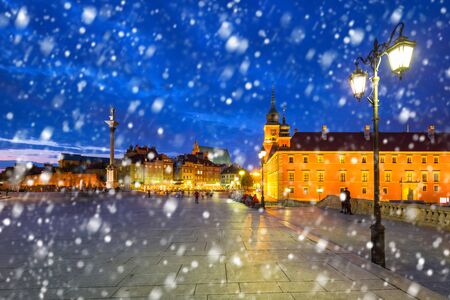Old town of Warsaw on a cold winter night with falling snow, Polandの写真素材
