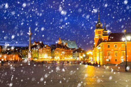 Old town of Warsaw on a cold winter night with falling snow, Polandの写真素材