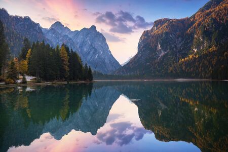 Dolomites mountains with reflection in Lago di Dobbiaca lake at autumn. Italyの写真素材