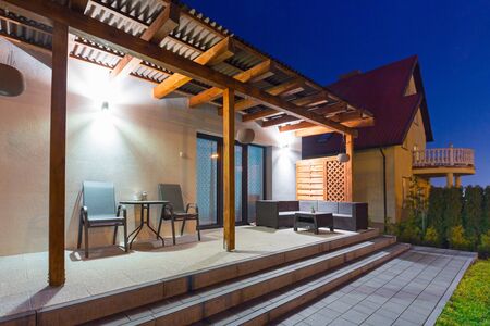 Home terrace with a roof in the night scenery of the gardenの写真素材