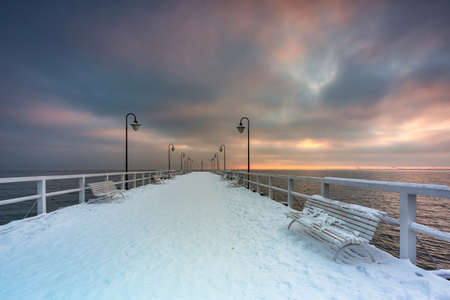 Beautiful wooden pier in Gdynia Orlowo at snowy winter, Baltic Sea. Polandの写真素材