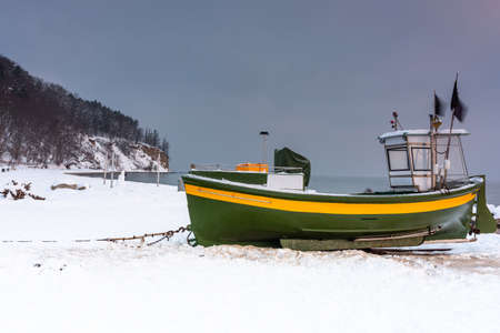 Fishing boat on snowy beach in Gdynia Orlowo at sunrise, Baltic Sea. Polandの写真素材