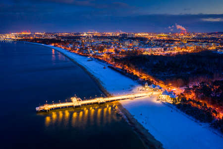 Illuminated pier in Brzezno on the winter beach at dusk, Gdansk.  Poland.の写真素材