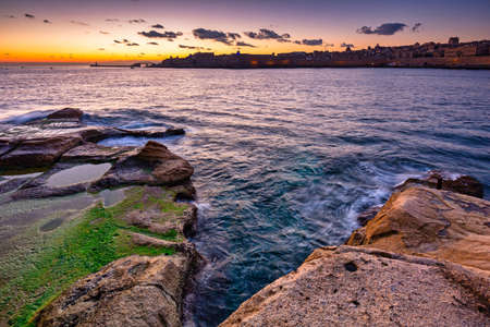 Rocky coastline of Malta and beautiful architecture of the Valletta city at dawnの写真素材
