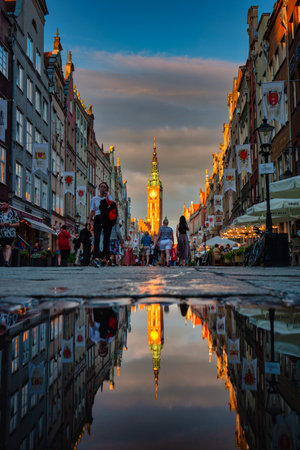 Gdansk, Poland - July 4, 2022: People are walking on the beautiful old town in Gdansk with historical city hall reflected in water, Poland.のeditorial素材