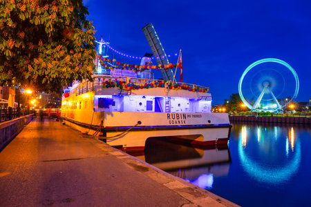 Gdansk, Poland - May 31, 2022: Beautiful Gdansk city reflected in the Motlawa River with the ferry and ferris wheel at dusk. Polandのeditorial素材