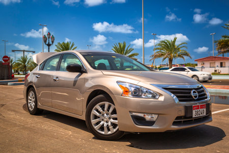 Abu DhabiI, UAE - March 27, 2014: Nissan Altima - rent car on the street of Abu Dhabi, capital of Emirates at sunny day, UAEのeditorial素材