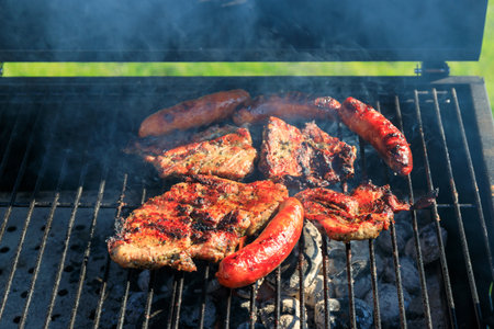 Grilled pork meat and sausages on the barbecueの写真素材