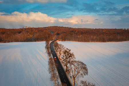 Aerial landscape of the road through snowy field at winter, Poland.の写真素材