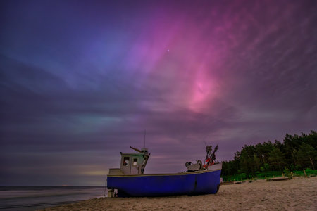 Aurora over the Baltic Sea on the beach in Katy Rybackie with fishing boat in Poland.の写真素材