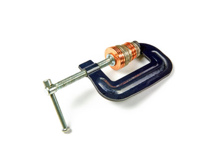 Money being squeezed in a clamp on a white backgroundの写真素材