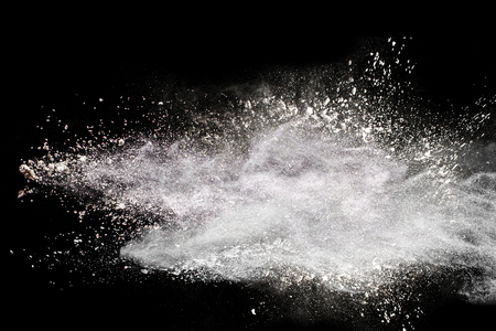 Launched white powder splash on black background.の写真素材