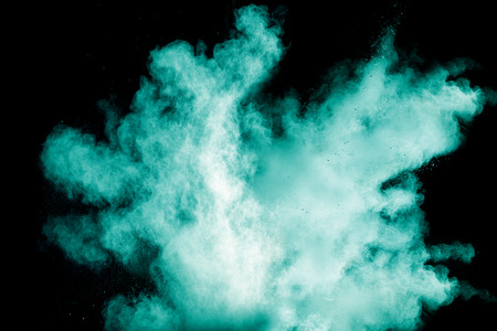 green color powder explosion cloud isolated on black background.の写真素材