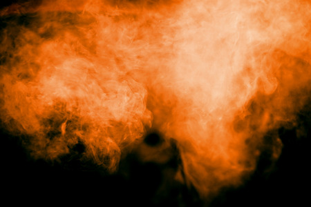 abstract orange dust explosion on  black background. abstract orange powder splattered on dark background, Freeze motion of orange powder splash. Painted Holi.の写真素材