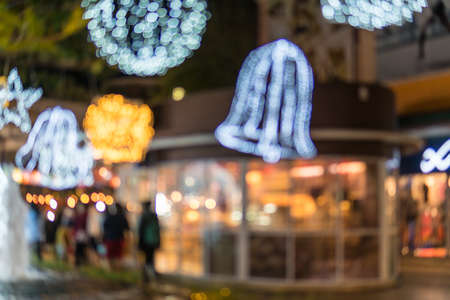 Blurred photo of Christmas lights. Festive New-year background with bokeh from Christmas tree lights glowing. Blurred colorful circles on light holiday background.の写真素材