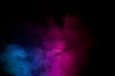 Pink blue dust particles splash on black background.Pink blue powder splash.の写真素材