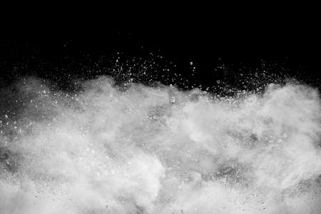 White powder explosion cloud against black background.の写真素材