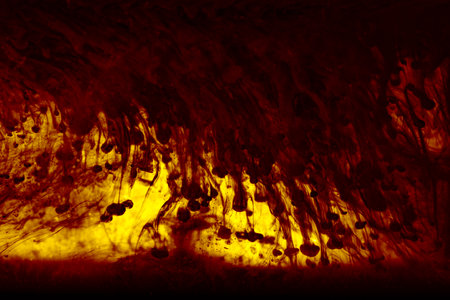 Abstract black alcrylic ink in water on yellow background.の写真素材