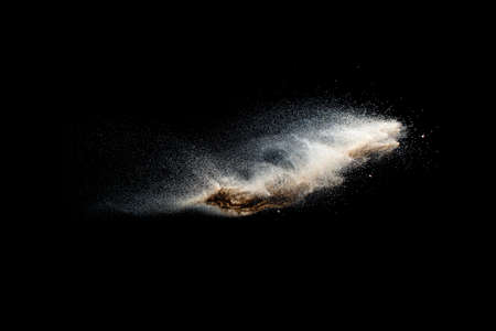 Sand explosion isolated on black background. Freeze motion of sandy dust splash.の写真素材