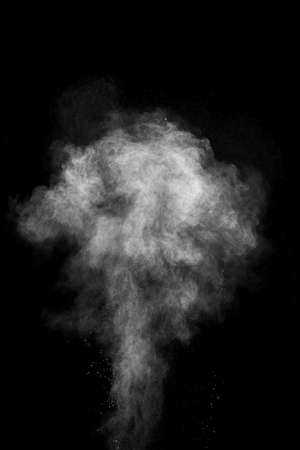 White powder explosion isolated on black background. White dust particles splash.Color Holi...