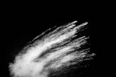 White powder explosion clouds.Freeze motion of white dust particles splash on black background.の写真素材
