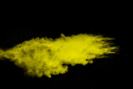 Yellow  powder explosion on white background. Freeze motion of yellow  dust particles splash.