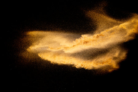 Dry river sand explosion.Brown color sand splash against black background.の写真素材