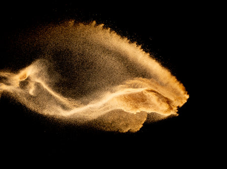 Dry river sand explosion.Brown color sand splash against black background.の写真素材