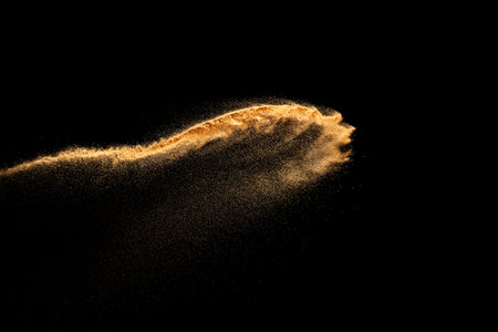 Sand explosion isolated on black background. Freeze motion of sandy dust splash.の写真素材
