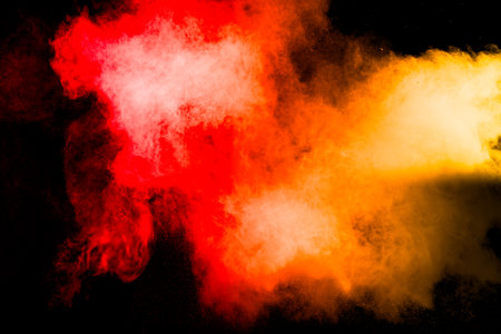 A red and orange cloud of smoke is blowing through the airの写真素材