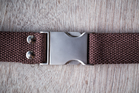 Dark brown canvas belt on wood backgroundの写真素材