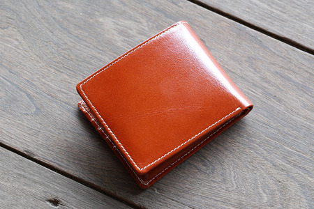 leather wallet brown leather on a wood backgroundの写真素材