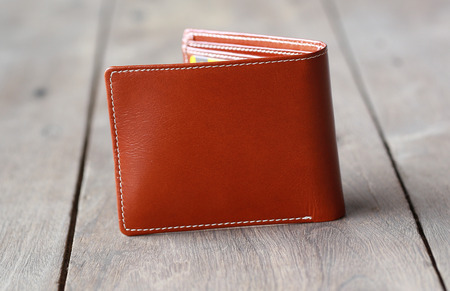 leather wallet brown leather on a wood backgroundの写真素材