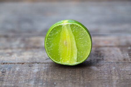 Limes with slices on wood backgroundの写真素材