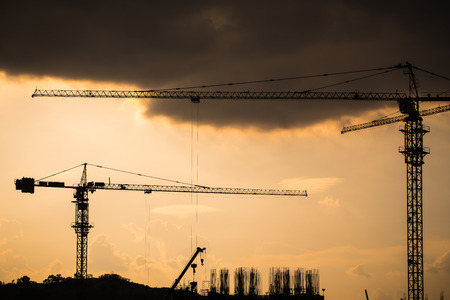 Industrial landscape with silhouettes of cranesの写真素材