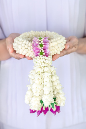 soft light tone with Jasmine garland of flowers on handの写真素材