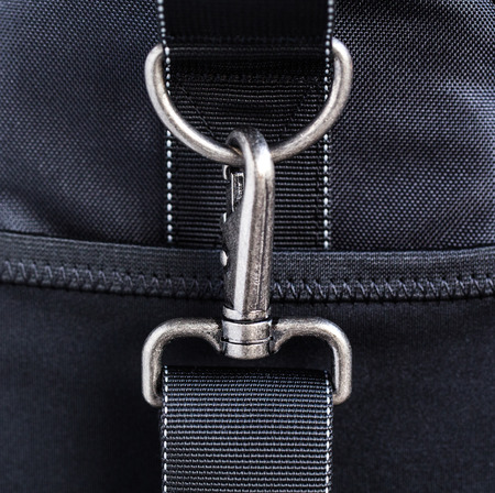Black belt rope strap lanyard, hanging metal clasp snap latch hook carabiner, isolated macro closeup latchの写真素材
