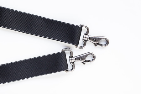 Black belt rope strap lanyard, hanging metal clasp snap latch hook carabiner, isolated macro closeup latchの写真素材