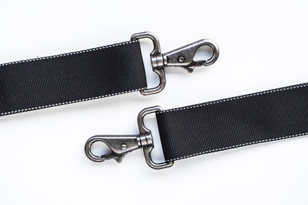 Black belt rope strap lanyard, hanging metal clasp snap latch hook carabiner, isolated macro closeup latchの写真素材