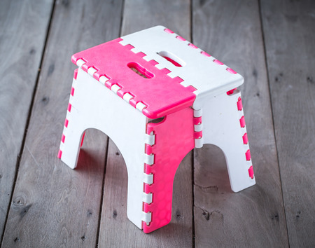 Folding stool isolated on wood backgroundの写真素材