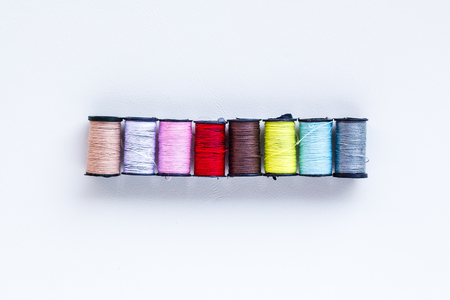 mini thread colored spools on white backgroundの写真素材