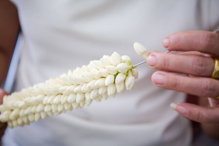soft light tone with Jasmine garland of flowers on handの写真素材